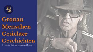 Eine schlichte Grafik – die linke Seite zeigt das Motto für 2026 „ Gronau – Menschen Gesichter Geschichten “ – darunter steht „ Gronau eine Stadt und einzigartige Menschen “. Auf der rechten Seite ein Portrait der Gronauer Rocklegende Udo Lindenberg – portraitiert von Tine Acke!
